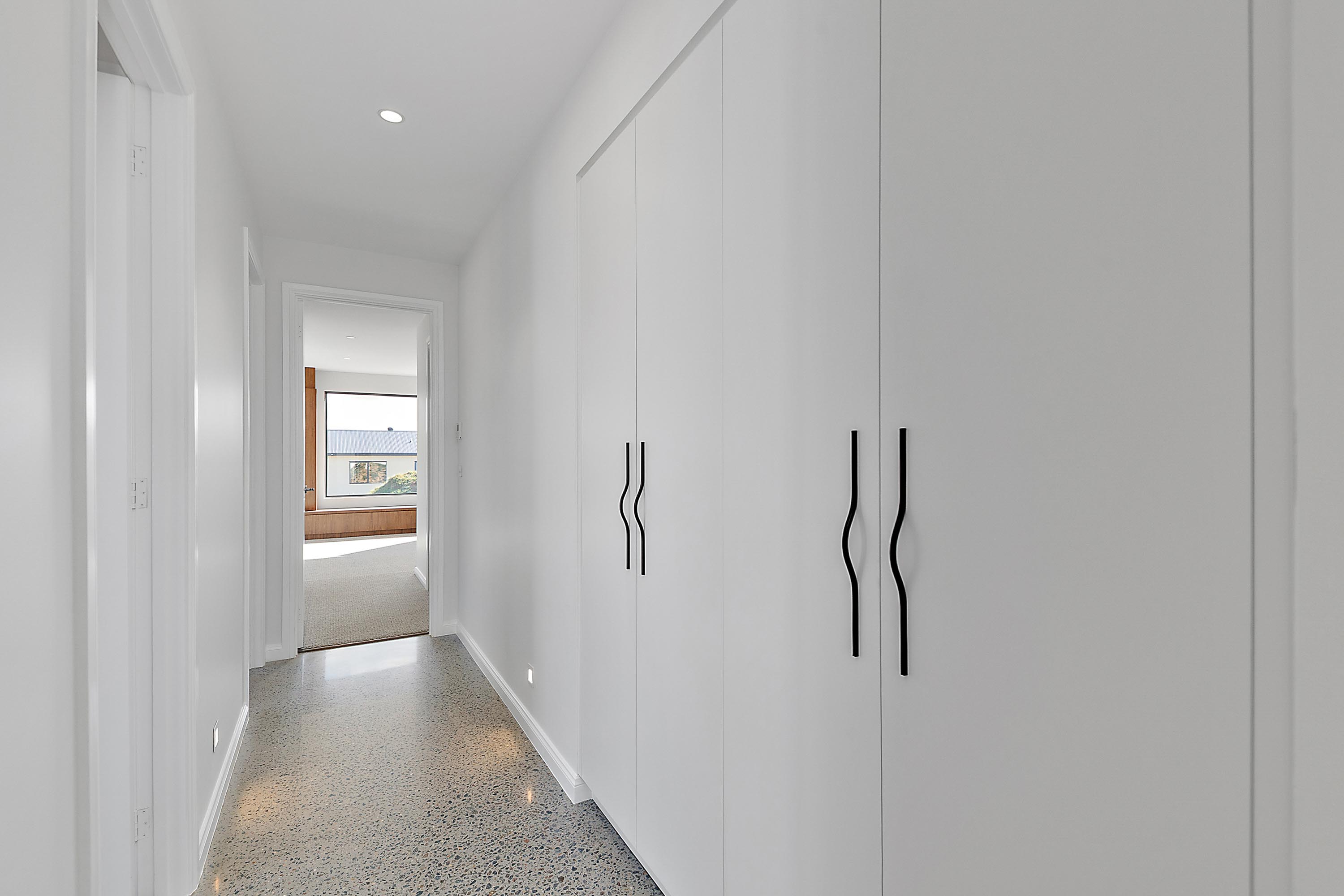 Hallway with white built-in cabinetry and black handles, 14 Blakelys Close Project, Sutton ACT